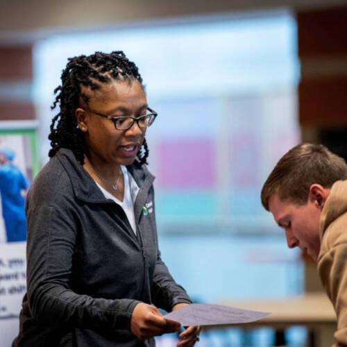 Employer reading a paper to a student.